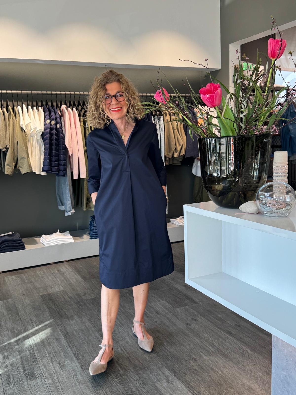 Christiane Zielke mit blauem Kleid und Blumen